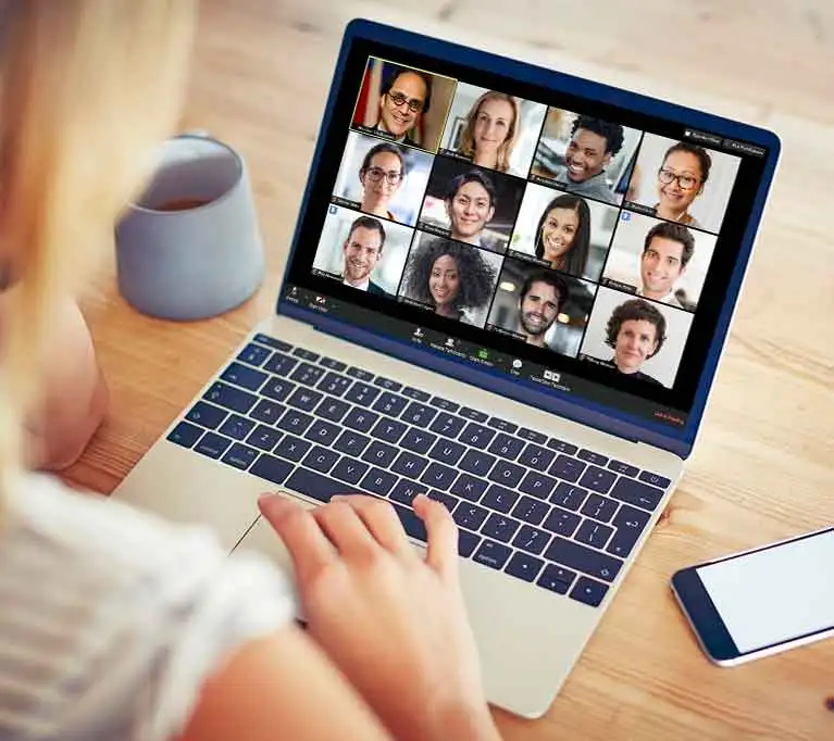 A student working on a laptop with a Zoom meeting in progress