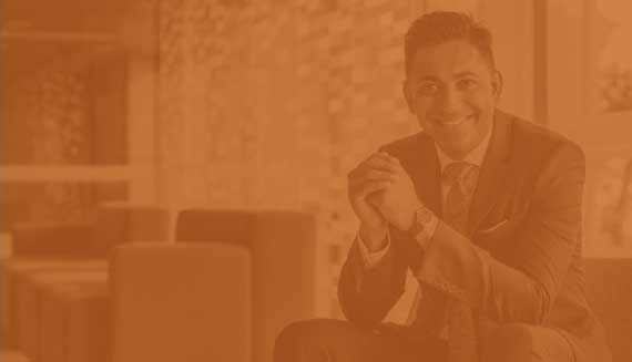 A man in a business suit sits in an office